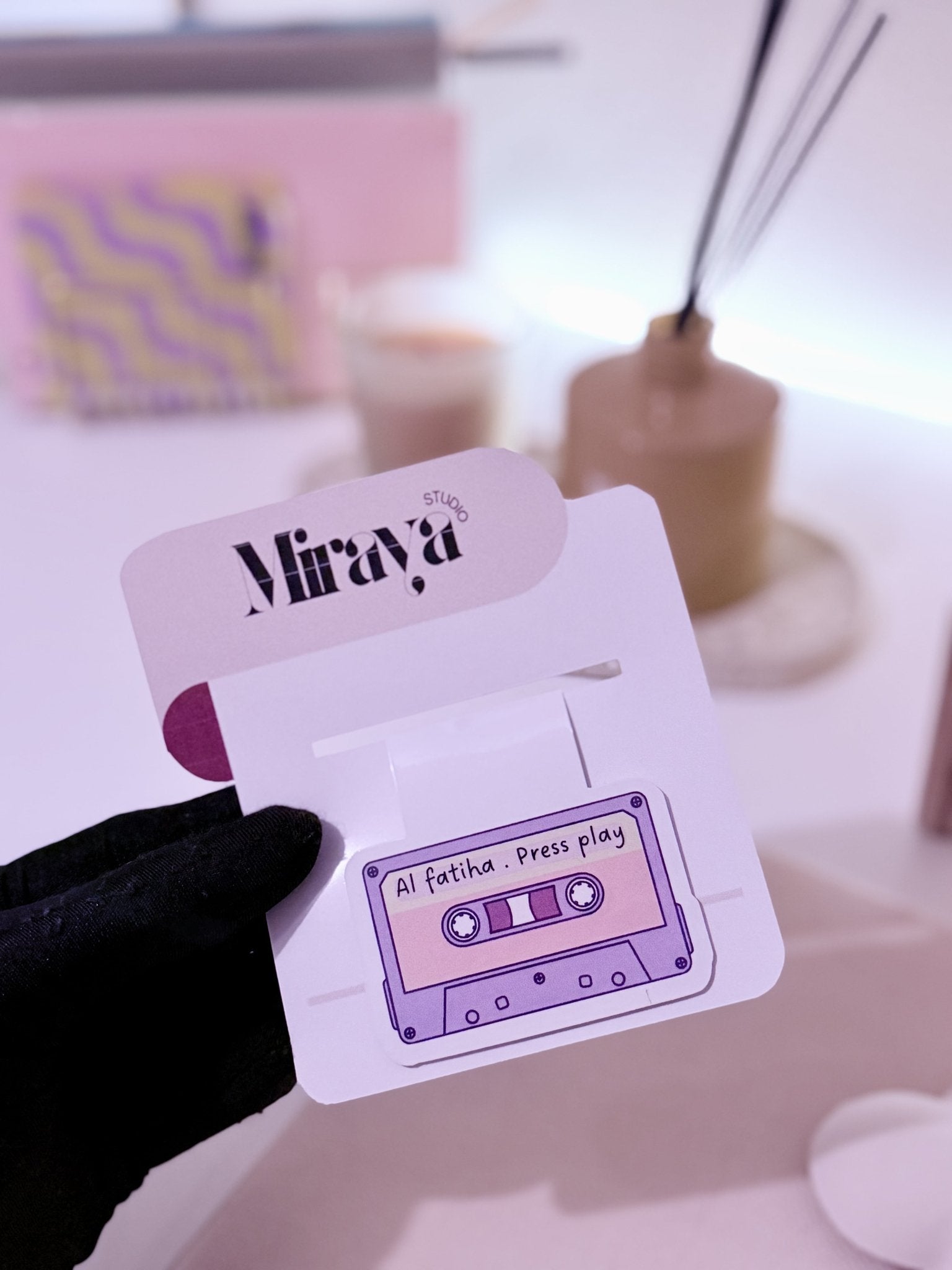 Marque page aimanté motif casette Al Fatiha rose  dans une main 