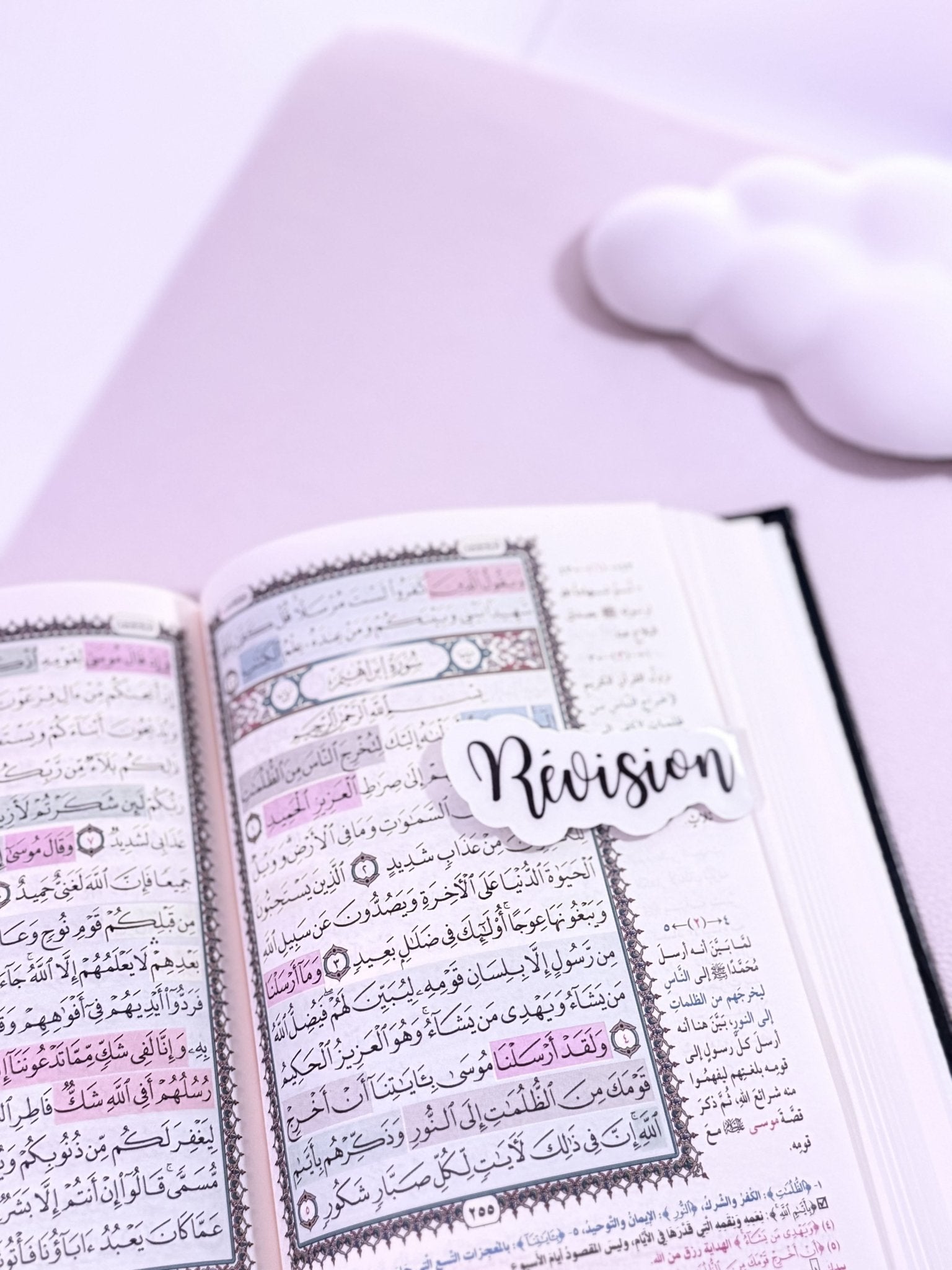 Coran ouvert avec un marque page aimanté noir sur fond blanc écrit "révision"