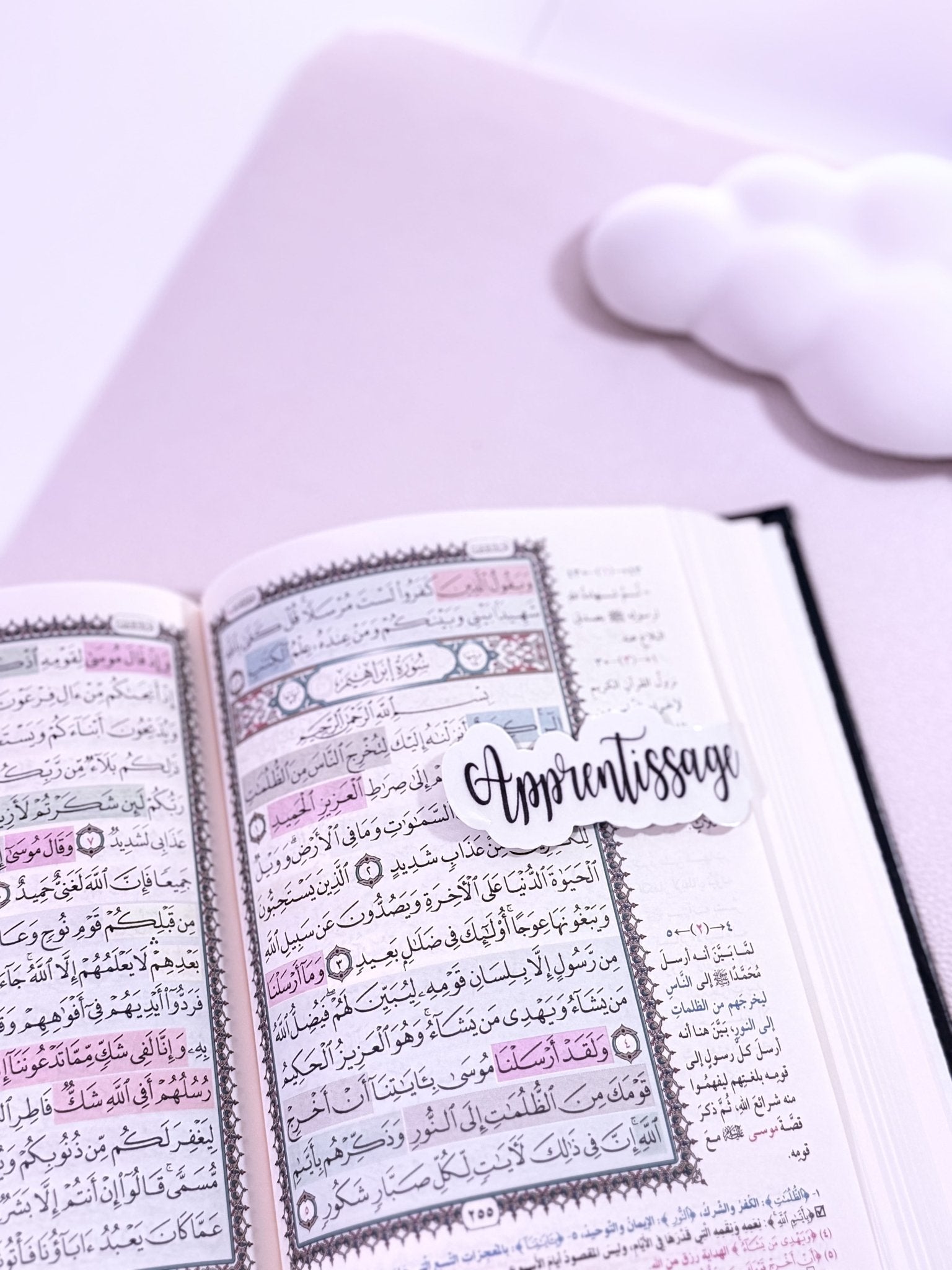 Coran ouvert avec un marque page aimanté écrit noir sur fond blanc "apprentissage"
