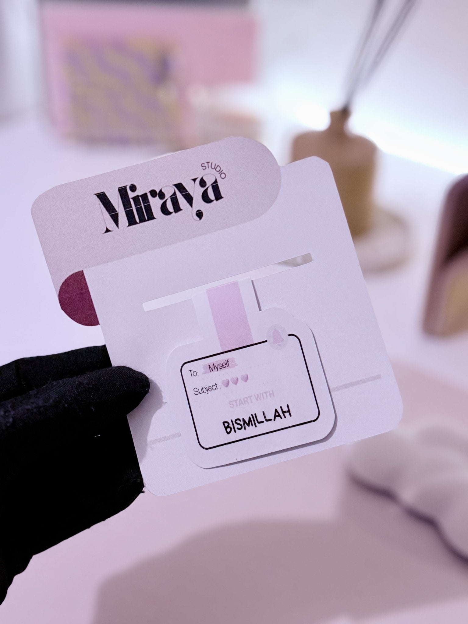 Marque aimante motif mail dans une main et sur son packaging