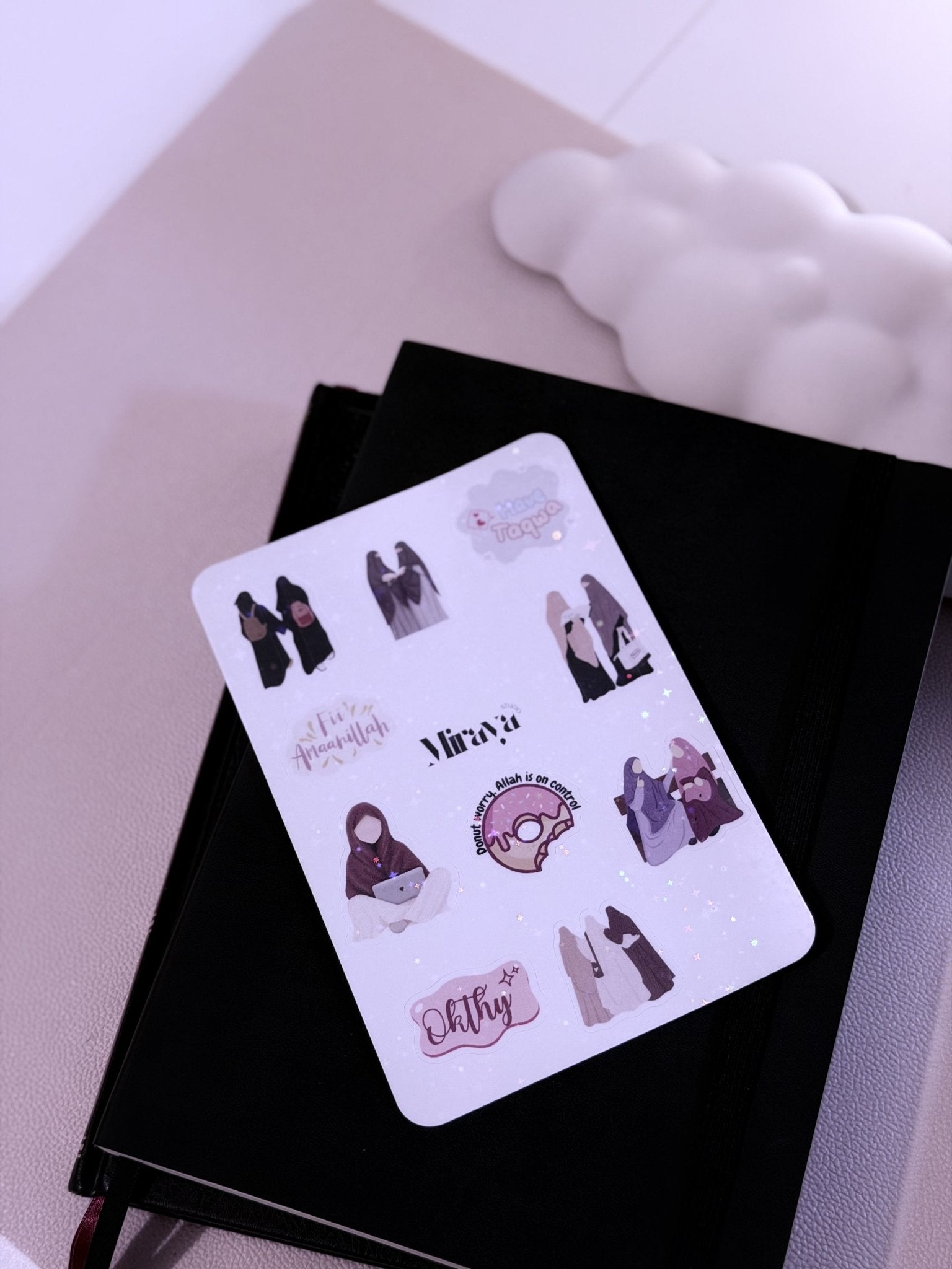 Une feuille de 10 stickers islamique posé sur un carnet noir