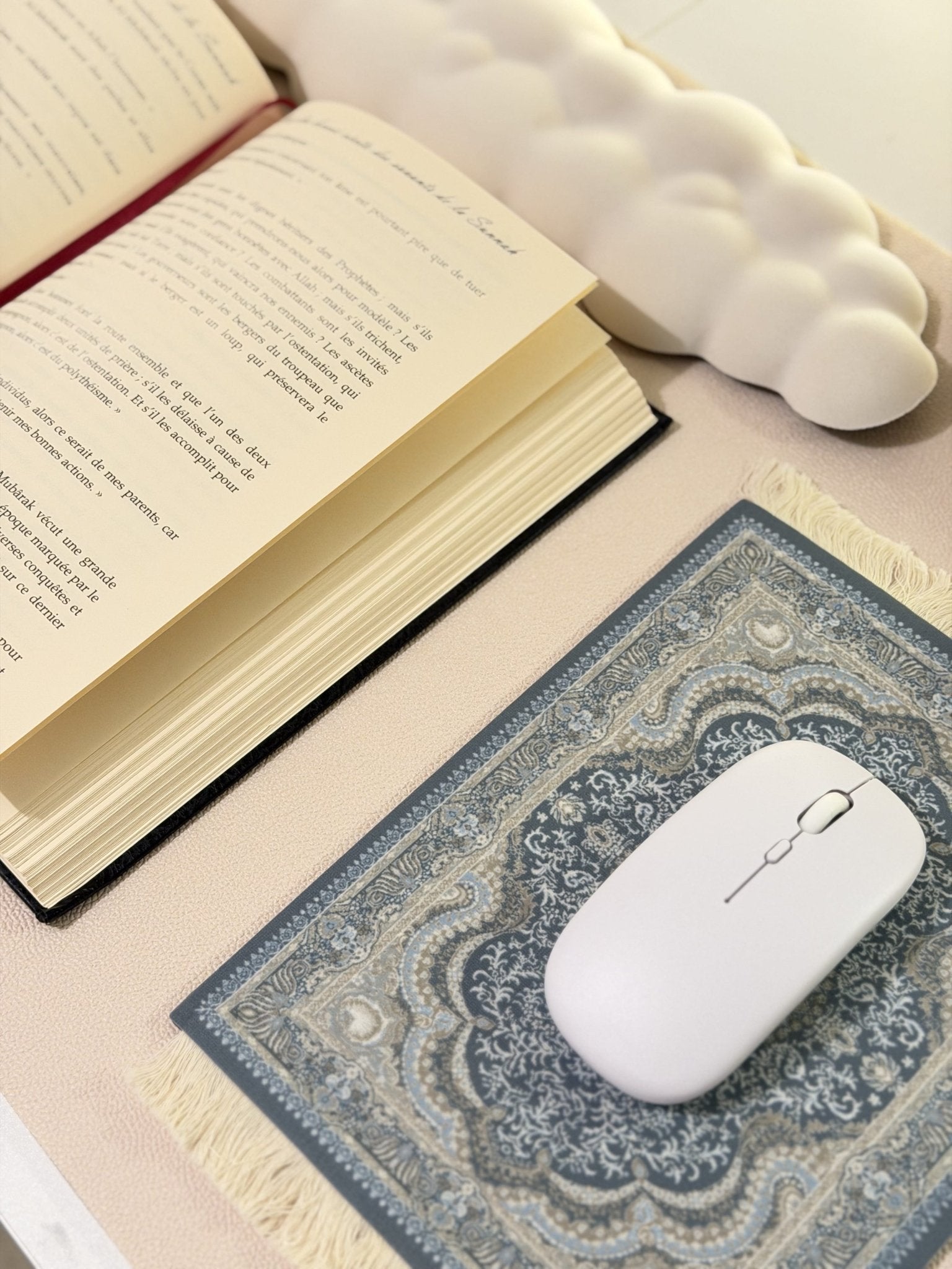 Un Tapis de souris bleu motif oriental posé sur bureau avec un livre ouvert
